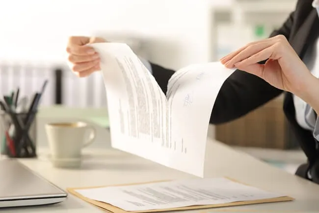 Woman tears a document in half