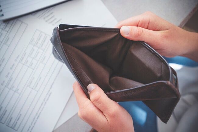 Man looks in empty wallet to assess RCP
