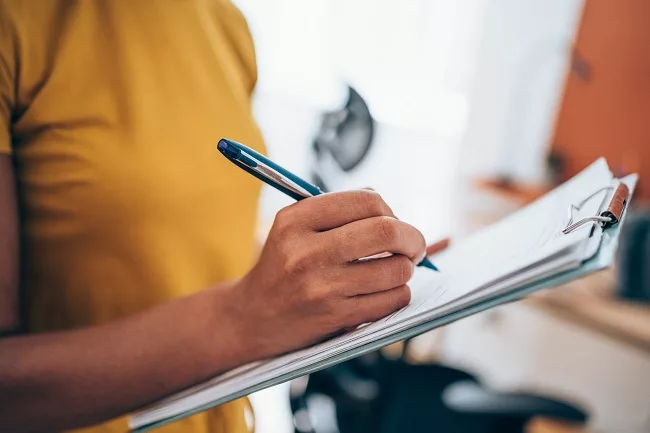 Woman completing checklist for IRS Tax Relief Form 433-F