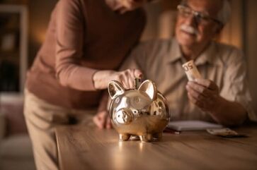 Couple sharing a joint savings account in a piggy bank