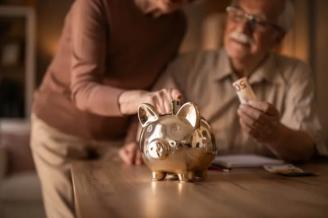 Couple sharing a joint savings account in a piggy bank