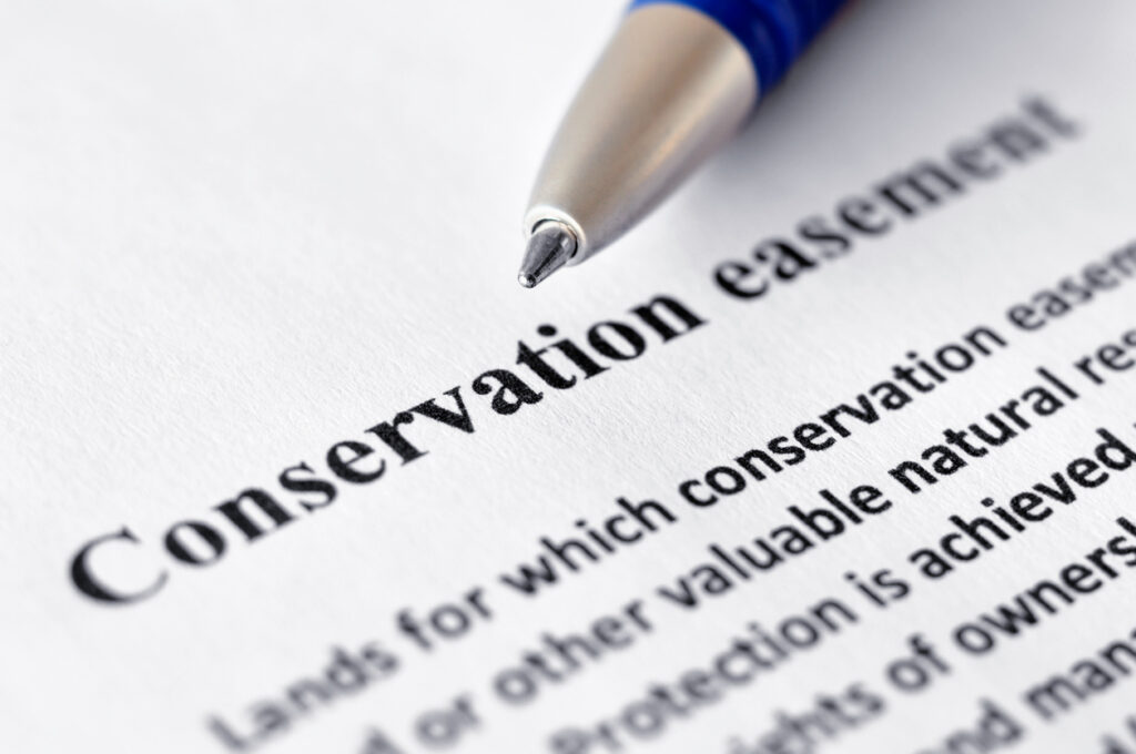 Close-up of paper reading New IRS Conservation Easement Lawsuits in Georgia with pen