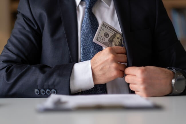 Man putting cash wages into pocket