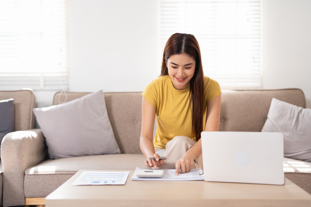 A smart business woman who keeps a paper account using a calculator, housewife manages the account's finances, calculates the tax on the cash budget, plans to pay off a bank loan debt