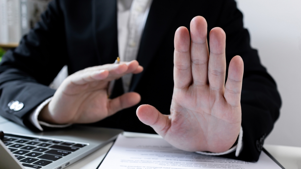Businessman hand stop sign. refusing to take bribe, anti-corruption laws in action, ban or prohibition gesture, rejecting offer, Never, no compromise.